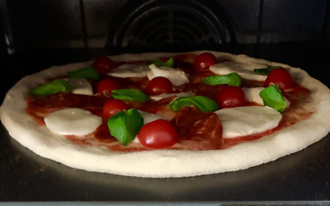 pizza på pizzastål i vanlig kjøkkenovn